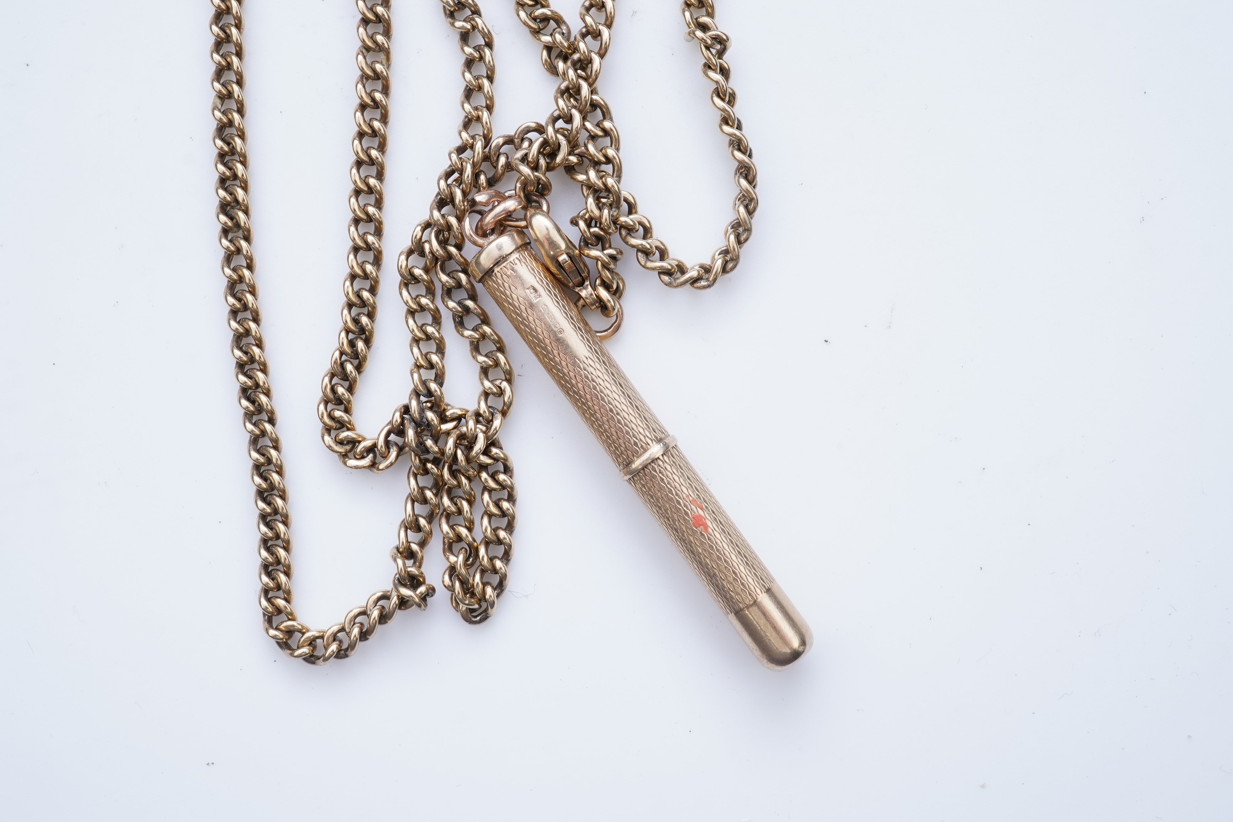A gold toothpick and chain necklace